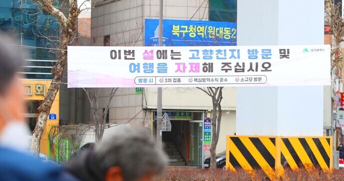 A placard hanging in northern Daegu’s Buk District on Monday advises residents to refrain from traveling and meeting up with others over the Lunar New Year holiday. (Yonhap News)