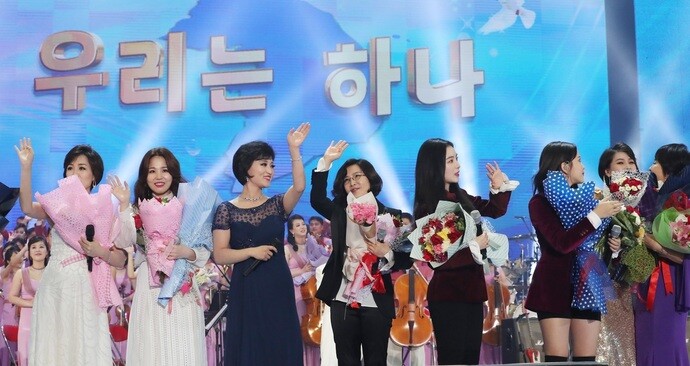 South and North Korean singers perform the song “Our Wish is Unification” in front of a background reading