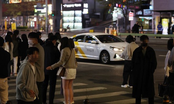 코로나 팬데믹 이후 택시기사가 배달 등으로 대거 이직해 수도권에서 밤 시간 택시 잡기가 매우 힘들어졌다. 지난 4월 서울 강남역 인근에서 자정이 넘은 시간에 시민들이 택시를 잡기 위해 길거리에 서 있다. 연합뉴스