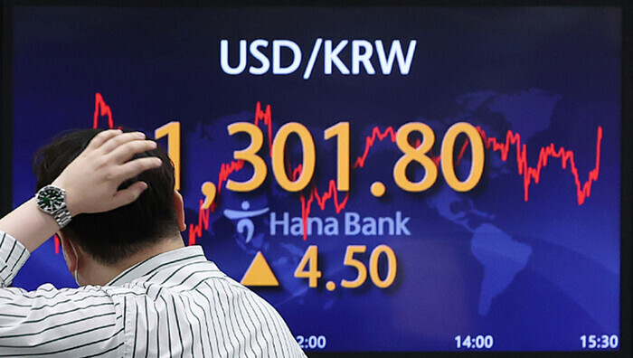 A person walks past a monitor showing the won-dollar exchange rate on June 23, 2022, at KEB Hana Bank’s headquarters in downtown Seoul. (Yonhap News)