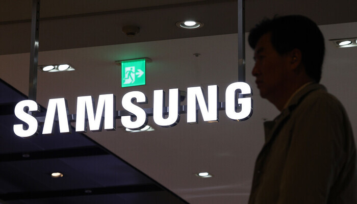 A person walks by a Samsung sign in this undated photo. (Yonhap)