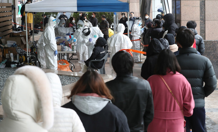 On Mar. 10, people line up to get tested for the novel coronavirus at a screening center outside a call center in Seoul’s Guro District where a transmission cluster was discovered. (Park Jong-shik, staff photographer)