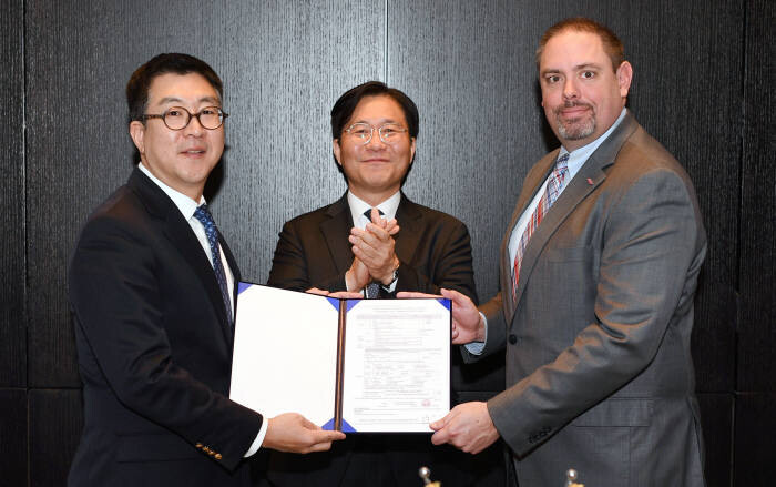DuPont Electronics and Imaging President Jon Kemp (right) submits an investment report on an EUV photoresist factory to Chang Sang-hyun (right), head of KOTRA Invest Korea in San Francisco on Jan. 8. South Korean Minister of Trade, Industry and Energy Sung Yun-mo stands between them. (provided by Ministry of Trade, Industry and Energy)