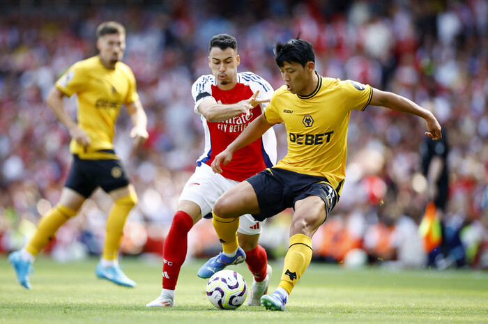 O jogador do Wolves, Hwang Hee Chan (à direita), compete pela bola na partida de abertura contra o Arsenal na temporada 2024-25 da Premier League, que será disputada no Emirates Stadium, em Londres, Inglaterra, no dia 17 (horário coreano). Londres/Reuters Yonhap News