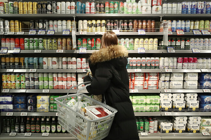 A shopper peruses the beer selection at a supermarket in Seoul. (Yonhap News)