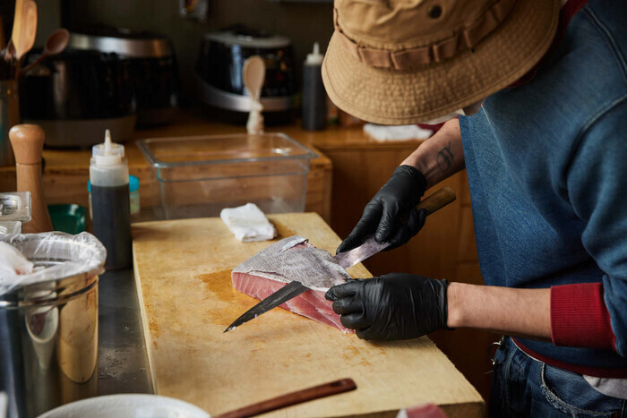 Kwon Deok, the owner of Katabuta, skins a flank of tuna. (Yoon Dong-gil/Studio Adapter)