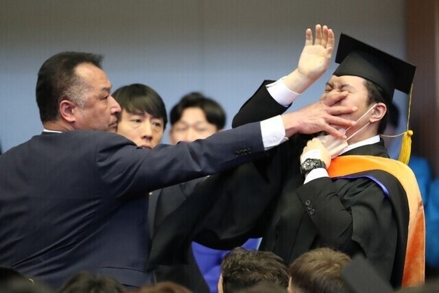 올해 2월 대전 유성구 한국과학기술원(KAIST) 학위수여식 도중 졸업생 신민기씨가 “알앤디 예산 복원하십시오”라고 소리치는 순간 경호원이 입을 막으며 제지하고 있다. 대전충남사진공동취재단