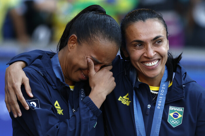 A brasileira Marta (à direita) consola a companheira de seleção após perder para os Estados Unidos na final do futebol feminino das Olimpíadas de Paris 2024, no Parc des Princes, em Paris, na França, no dia 10 (horário local). Notícias Paris/AP Yonhap