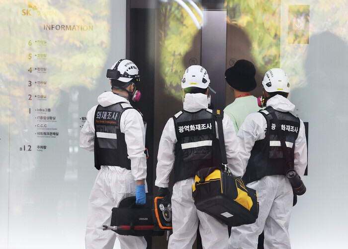 Police and fire department officials head into the site of the fire in the SK C&C building in the Sampyeong neighborhood of Seongnam, Gyeonggi Province, on Oct. 16 for the first round of analysis of the fire that caused outages of Kakao services. (Yonhap)