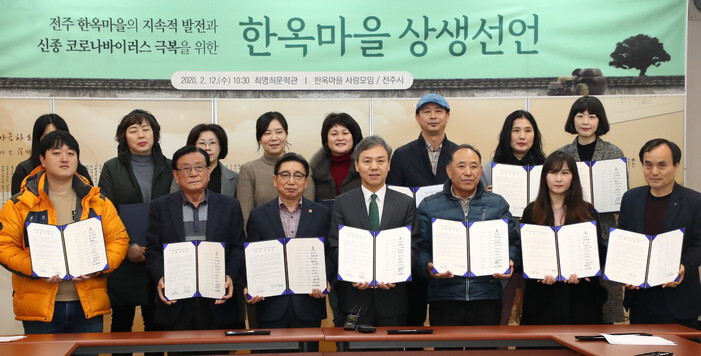On Feb. 12, building owners of Jeju Hanok Village sign a declaration to lower rent for business owners who are struggling with slow business amid the novel coronavirus outbreak. (provided by the city of Jeonju)