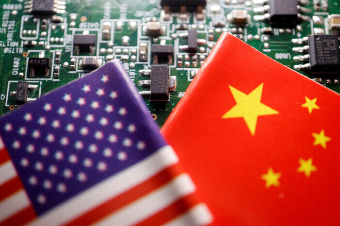 The American and Chinese flags are shown against the backdrop of a printed circuit board. (Reuters/Yonhap)