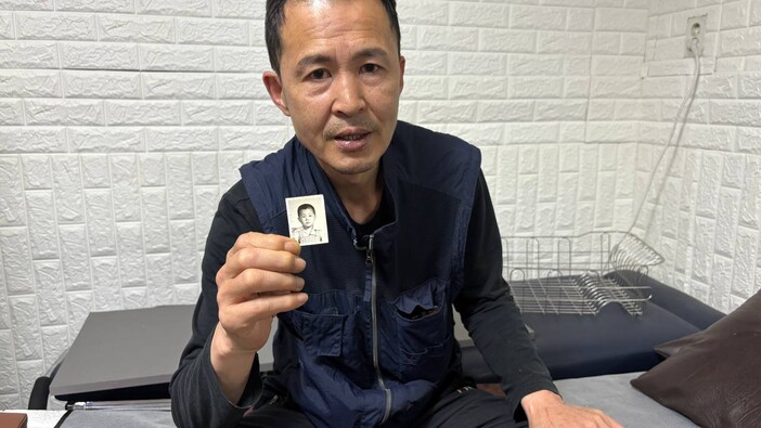 지난 12일 서울 관악구의 한 병원에서 만난 송준영(55)씨가 지갑에 보관해둔 어린 시절 사진을 보여주고 있다. 이나영 기자