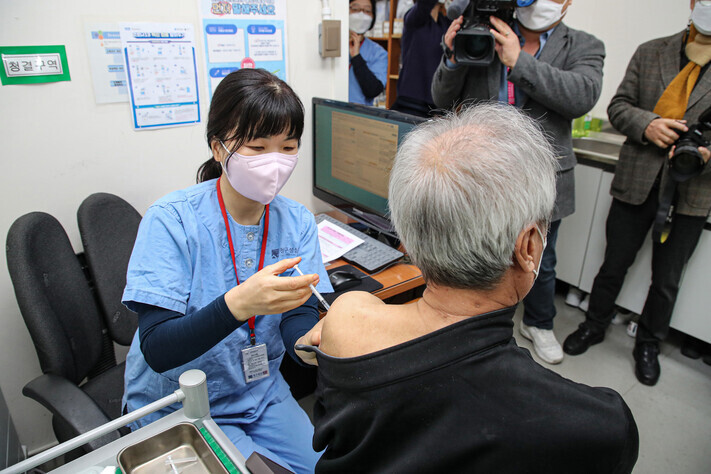 A healthcare worker administers a COVID-19 booster shot to a man at a hospital in Seoul’s Eunpyeong District on Saturday. (Yonhap News)