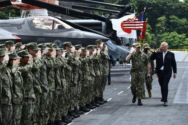 US President Donald Trump salutes troops aboard the USS Wasp in Yokosuka
