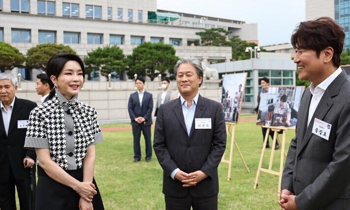 김건희 여사가 2022년 6월 12일 오후 서울 용산 대통령실 청사 잔디마당에서 열린 영화관계자 초청 만찬에서 한국 배우 최초로 칸국제영화제에서 남우주연상을 받은 배우 송강호, 감독상을 수상한 박찬욱 감독과 대화하고 있다. 연합뉴스