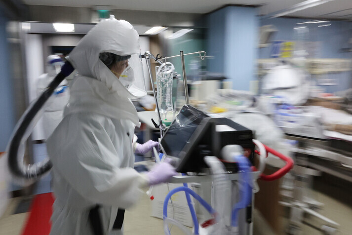 A medical worker at a dedicated COVID-19 hospital in Gyeonggi Province’s Pyeongtaek rushes to attend to patients on Monday. (Yonhap News)
