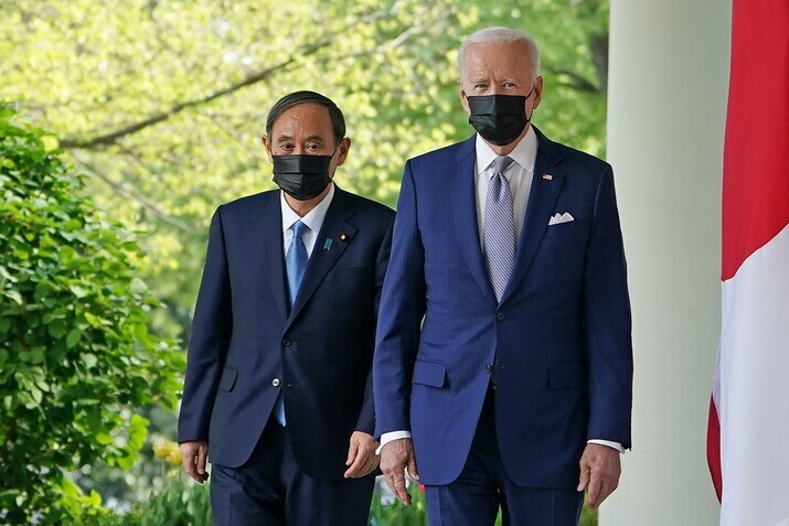 US President Joe Biden and Japanese Prime Minister Yoshihide Suga walk through the Colonnade to take part in a joint press conference in the Rose Garden of the White House on Friday. (AFP/Yonhap News)