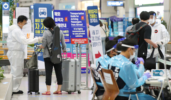 Arrivals at Incheon International Airport go through quarantine procedures on July 13. (Yonhap News)
