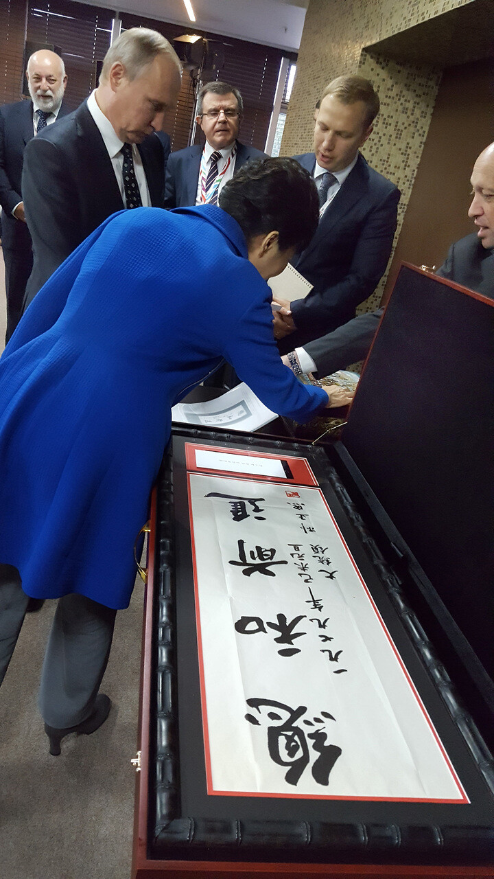President Park Geun-hye presents President Vladimir Putin with a piece of calligraphy written by her father
