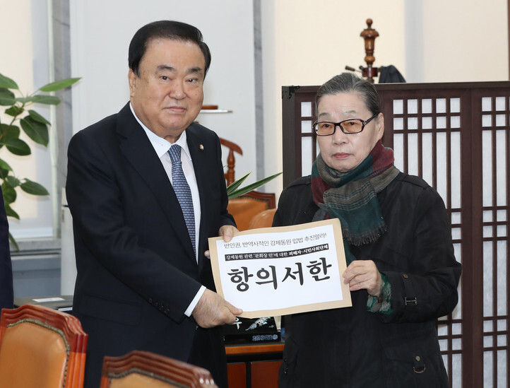 A leader of a civic group delivers a letter of protest to the National Assembly Speaker Moon Hee-sang regarding his proposed solution to the forced labor issue on Nov. 27. (Yonhap News)