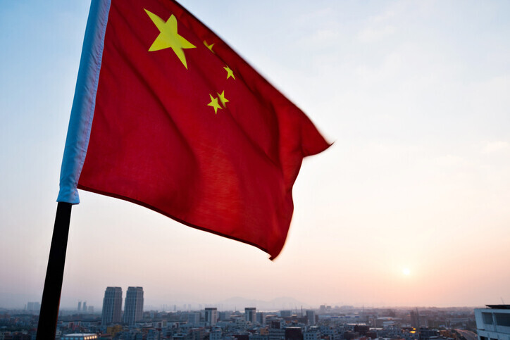 Chinese national flag waves in the wind over a city. (Getty Images Bank)