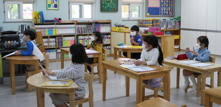 지난 2020년 5월6일 경남 김해 관동초등학교에서 1학년 학생들이 마스크를 낀 채 거리를 두고 앉아 돌봄교실 수업을 듣고 있다. 연합뉴스
