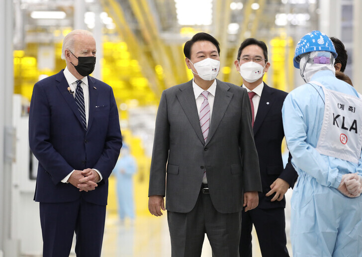 US President Joe Biden (left) and South Korean President Yoon Suk-yeol (center) receive a tour from Samsung Electronics’ Vice Chairman Lee Jae-yong (center back) around the company’s chip factory in Pyeongtaek, Gyeonggi Province, on May 20. (pool photo)