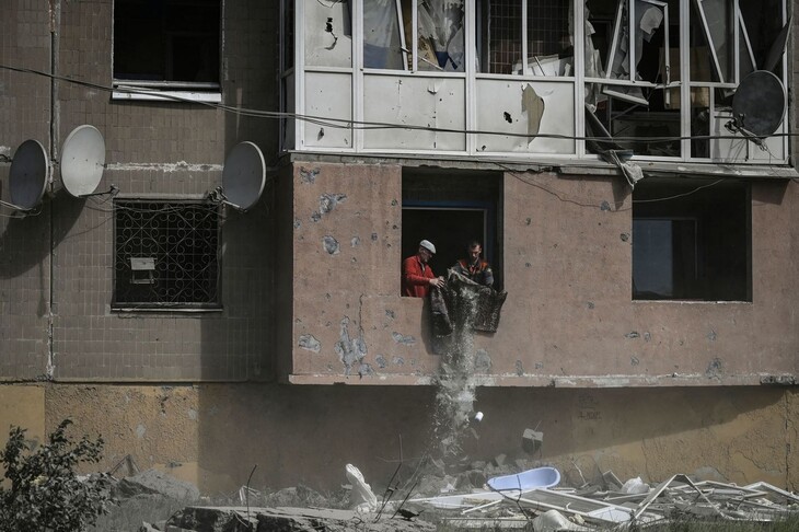 민간인 탈출이 이어지고 있는 우크라니아 동부 도네츠크주 크라마토르스크에서 25일(현지시각) 두 남성이 폭격으로 파괴된 아파트의 잔해를 치우고 있다. 크라마토르스크/AFP 연합뉴스