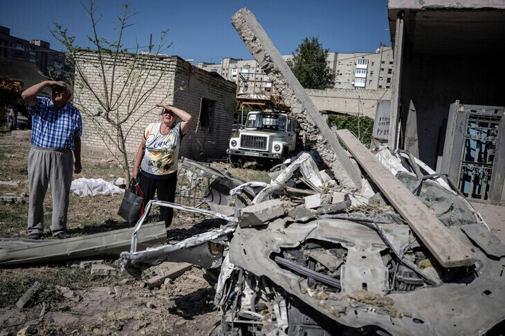 Two people stand in the ruins of a building in Pokrovsk, Ukraine, that was brought down by a Russian missile attack. (Reuters/Yonhap)