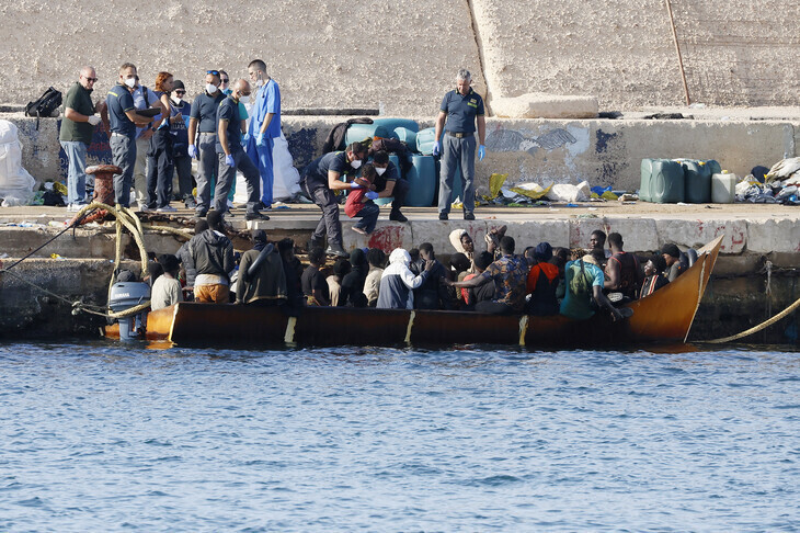 Migrants disembark from a small boat after arriving at Lampedusa, Italy, on Sept. 16. (AP/Yonhap)