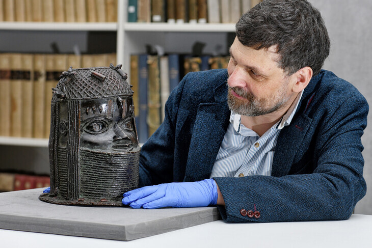 Neil Curtis, Head of Museums and Special collections, is seen with one of the Benin bronze works depicting the Oba of Benin at the Sir Duncan Rice Library, the University of Aberdeen, in Aberdeen, Scotland, on March 17. (Reuters/Yonhap News)