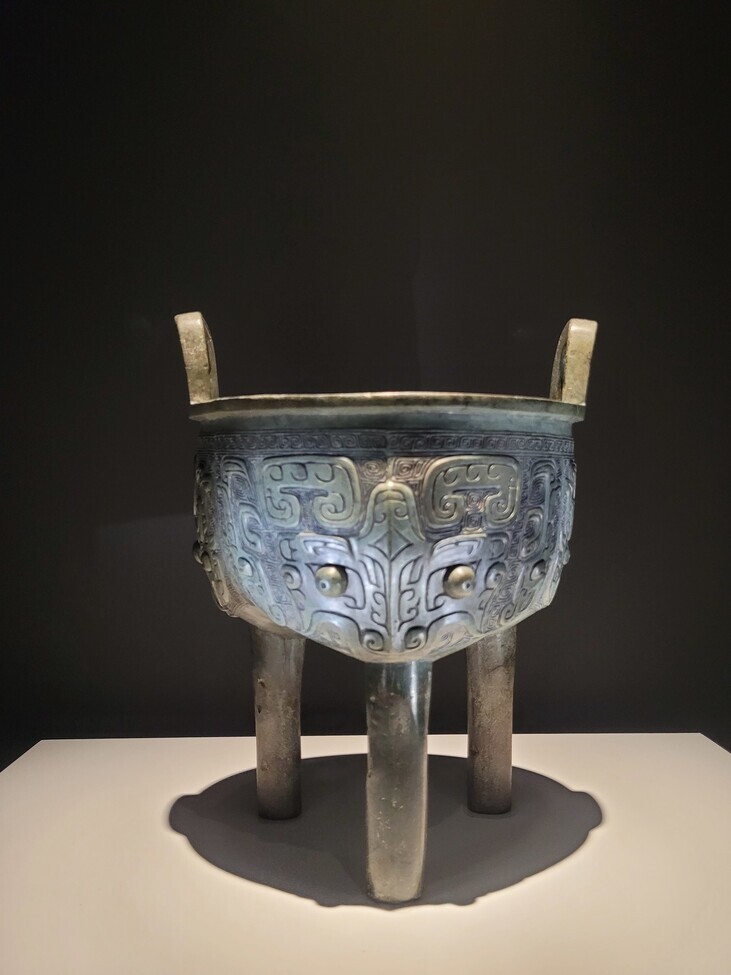 A tripod cauldron used to cook meat dating back to the Western Zhou era between the 11th and late 10th centuries BCE. Its body is emblazoned with faces of the taotie, a grotesque mythical creature. (Roh Hyung-suk/The Hankyoreh)