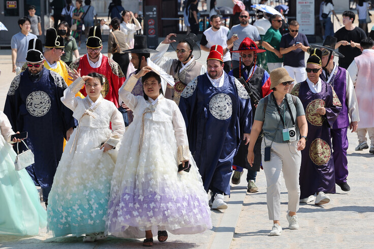 Foreign tourists in traditional Korean garb walk through Gyeongbuk Palace in Seoul on June 13, 2023. (Yonhap)