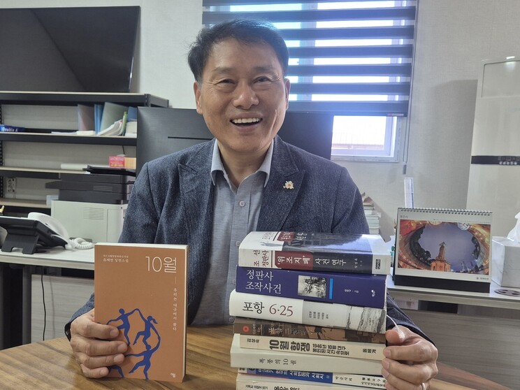지난 2일 경북 포항시 남구 상도동의 한 사무실에서 만난 환경운동가 유성찬씨가 자신이 쓴 소설 ‘10월-우리는 대구에서 왔다’(왼쪽)와 집필에 참고한 책들을 소개하고 있다.                                      주성미 기자