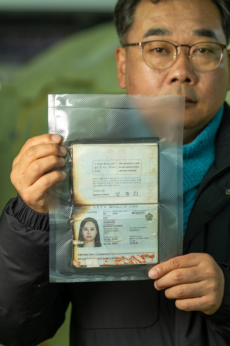 무안 제주항공참사로 아내와 두 아이를 잃은 김영헌씨가 2025년 12월15일 전남 무안 공항에서 고인의 불타다 남은 여권을 들어 보이고 있다. 무안(전남)=김진수 선임 기자 jsk@hani.co.kr