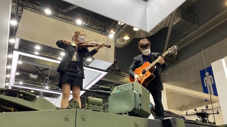 2022년 9월 대한민국 방위산업전 행사장 내 장갑차 위에서 바이올린을 연주하는 쭈야(김은미·왼쪽)와 기타 연주자 펭귄. 전쟁없는세상 제공