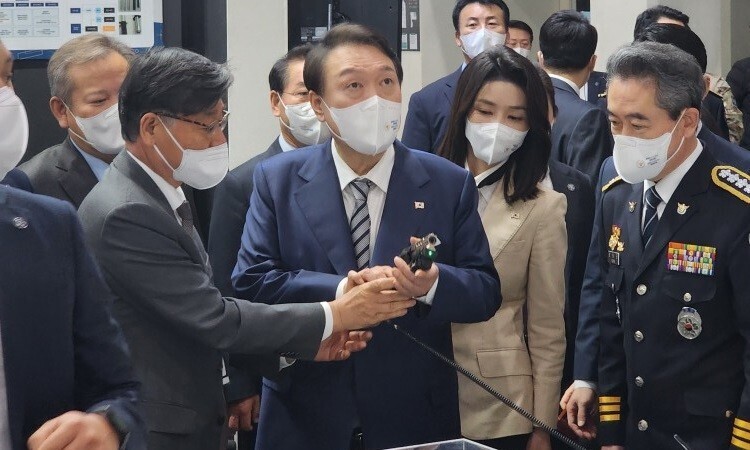 President Yoon Suk-yeol listens to an explanation about less lethal firearms while attending the Korea Police World Expo in October of 2022. (courtesy of SNT Motiv)