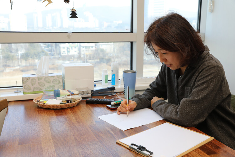 박연선 작가가 작업실 테이블에서 인물을 그리고 있다. 류우종 기자