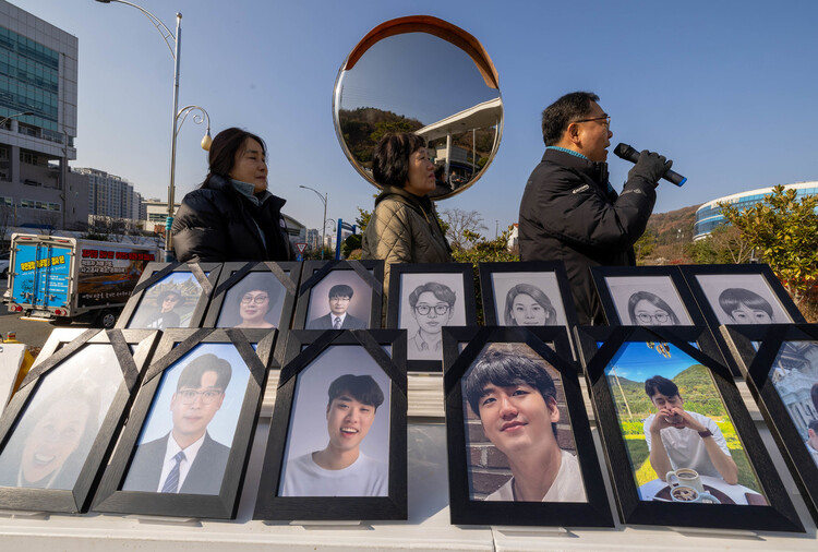 전남 무안공항 제주항공 참사로 아내와 두 아들을 잃은 김영헌씨와 유가족들이 2025년 12월15일 무안 전남경찰청 앞에서 사고 진상 규명을 요구하며 시위하고 있다. 아랫줄 왼쪽 맨 끝부터 김씨의 아내, 두 아들의 사진이다. 무안(전남)=김진수 선임기자 jsk@hani.co.kr
