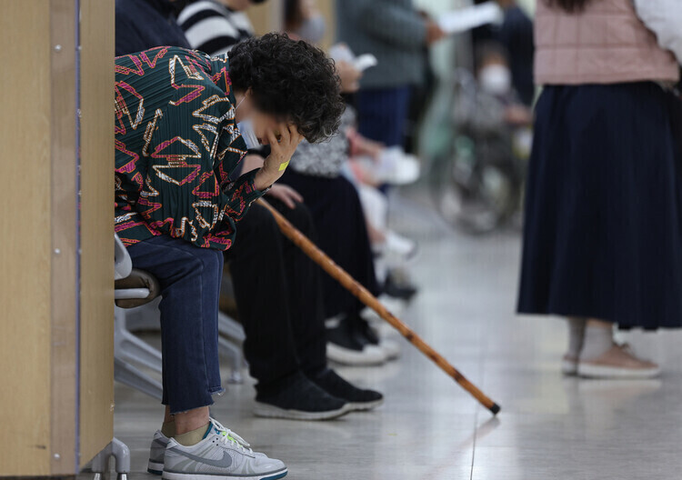 A person in a waiting room at a university hospital in Daegu holds their head in their hand. (Yonhap)