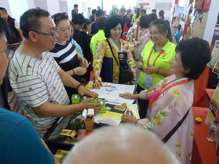 A Chinese visitor buys herbal medicine from a North Korean vendor at the China-Northeast Asia Expo in Changchun