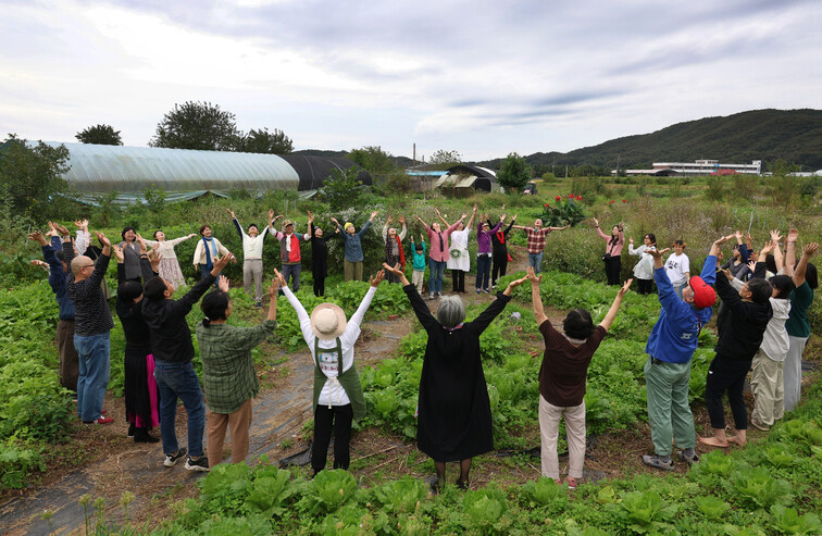 사단법인 ‘평화마을짓자’가 2025년 10월9일 경기도 파주시 적성면 식현리 평화밭에서 연 가을잔치에서 참가자들이 평화의 춤을 추며 하늘을 향해 두 팔을 뻗고 있다.
