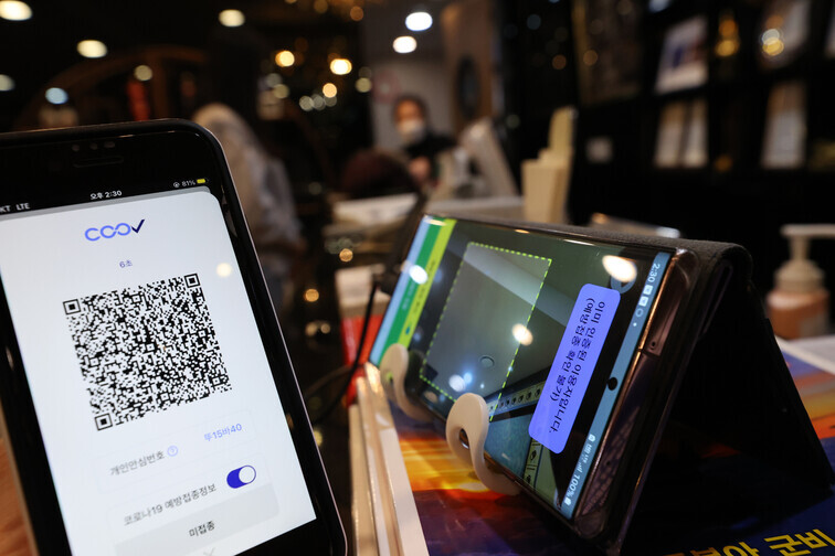A person who has not been vaccinated against COVID-19 uses a QR code to check in at a restaurant in Seoul’s Jongno District on Monday. (Yonhap News)