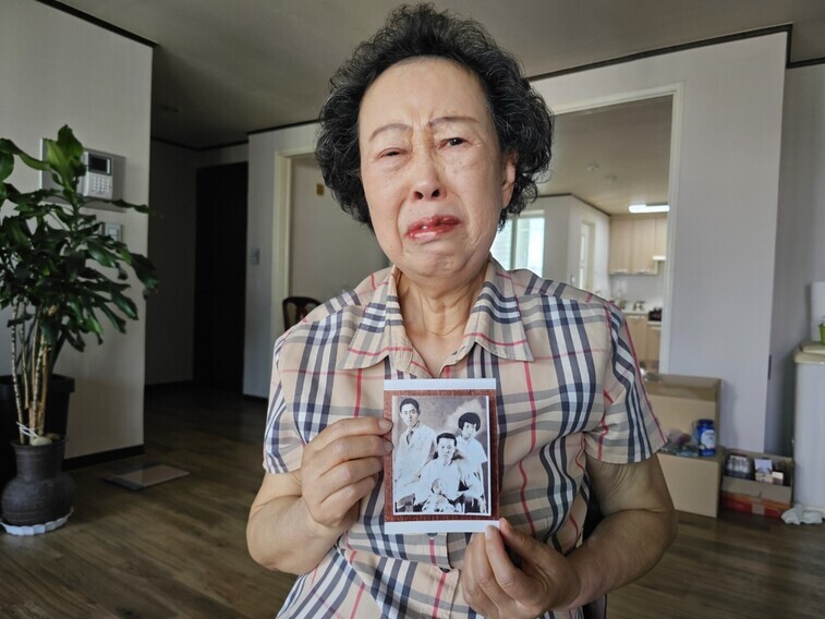 Im Nam-sin, the daughter of Gollyeong Valley massacre victim Im Sun-jae, holds the only photo she has of her and her father while speaking to the Hankyoreh at her home in Daegu on June 2. (Choi Ye-rin/The Hankyoreh)