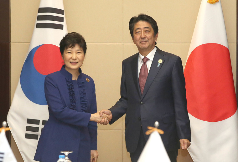 Pres. Park Geun-hye shakes hands with Japanese Prime Minister Shinzo Abe before their bilateral summit at the National Convention Center in Vientiane