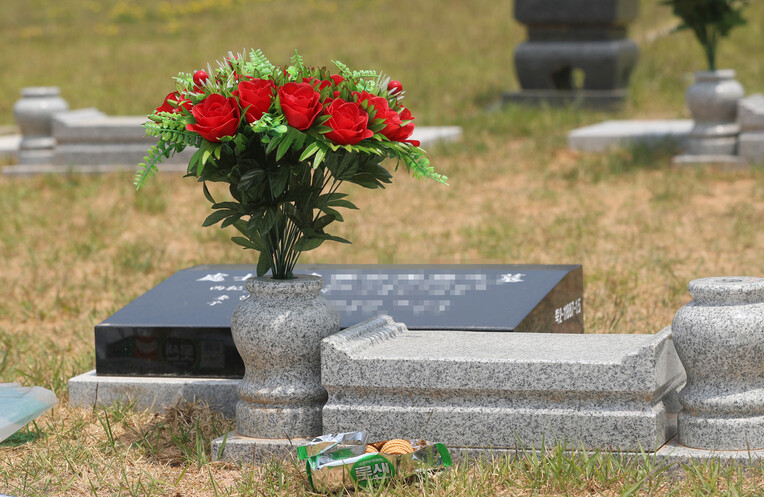코로나19로 숨진 최규식(가명·67)씨의 묘 앞에 생전에 좋아했던 과자가 놓여 있다. 경주/신소영 기자 viator@hani.co.kr