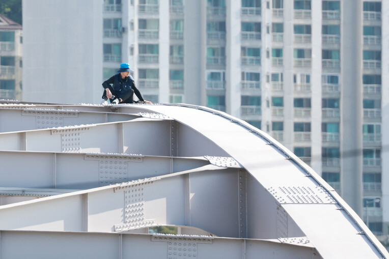 11일 서울 한강대교 아치 위에 오른 ㄱ보육원 출신 송준영(55)씨가 과거 보육원에서 폭력을 당한 피해자들에 대해 국가와 지방자치단체의 배상 및 보상을 촉구하며 농성을 벌이고 있다. 연합뉴스