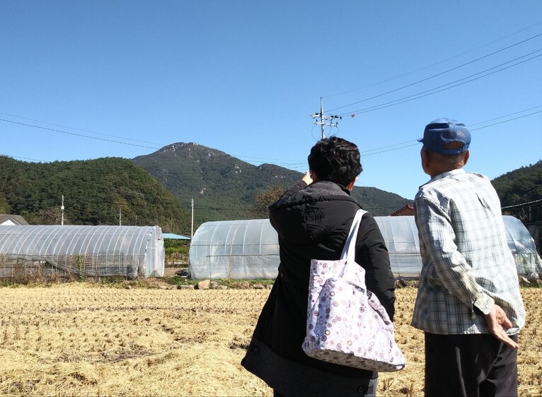 2021년 10월23일, 2기 진실화해위 조사관(왼쪽)이 전남 화순군 백아면(옛 북면) 수리마을에서 이 마을 주민 김아무개씨에게 1950년 12월 이 마을에서 벌어진 총살 사건에 대한 증언을 듣고 있다. 1937년생인 김씨는 1950년 12월12일 16명의 수리마을 주민이 국군에 의해 희생됐다고 증언했다. 멀리 보이는 산이 백아산이다. 진실화해위 제공