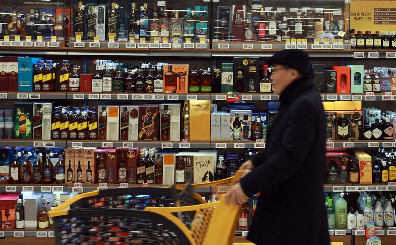 A shopper passes by shelves filled with liquor at a big-box grocery store in Seoul on Jan. 7. (Yonhap)