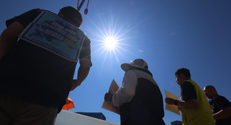 2025년 7월11일 서울 종로구 정부서울청사 앞에서 정부 규제개혁위원회의 폭염 규칙 통과 촉구 기자회견을 하는 민주노총 조합원 위로 뙤약볕이 내리쬐고 있다. 연합뉴스